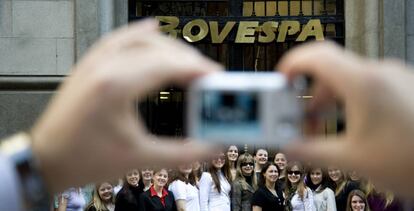 Una persona fotograf&iacute;a toma un foto de grupo ante la fachada de la Bolsa de S&atilde;o Paulo (Brasil).