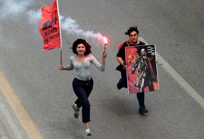 Duas mulheres correm por uma rua em Ancara (Turquia) durante os protestos do 1º de Maio.