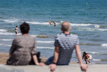 Dos personas miran el mar en Valencia.