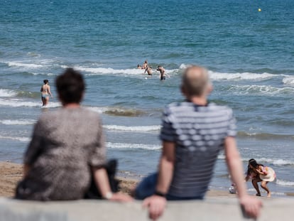 Dos personas miran el mar en Valencia.