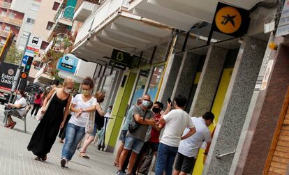 Gente paseando delante de oficinas de Sabadell, Bankia y CaixaBank