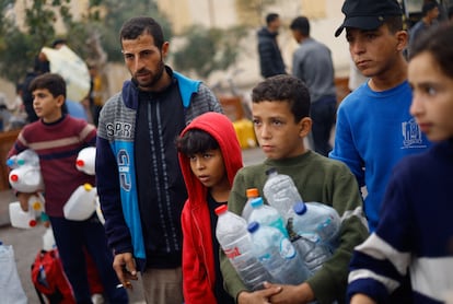 Niños palestinos hacen cola para recoger agua en Rafah, este martes. 