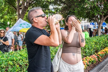 Dos personas hacen sonar conchas de caracol, este sábado durante la marcha contra el turismo masificado en Santa Cruz de Tenerife. 