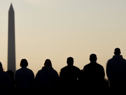 Un grupo de hombres y mujeres observa el obelisco de Washington.