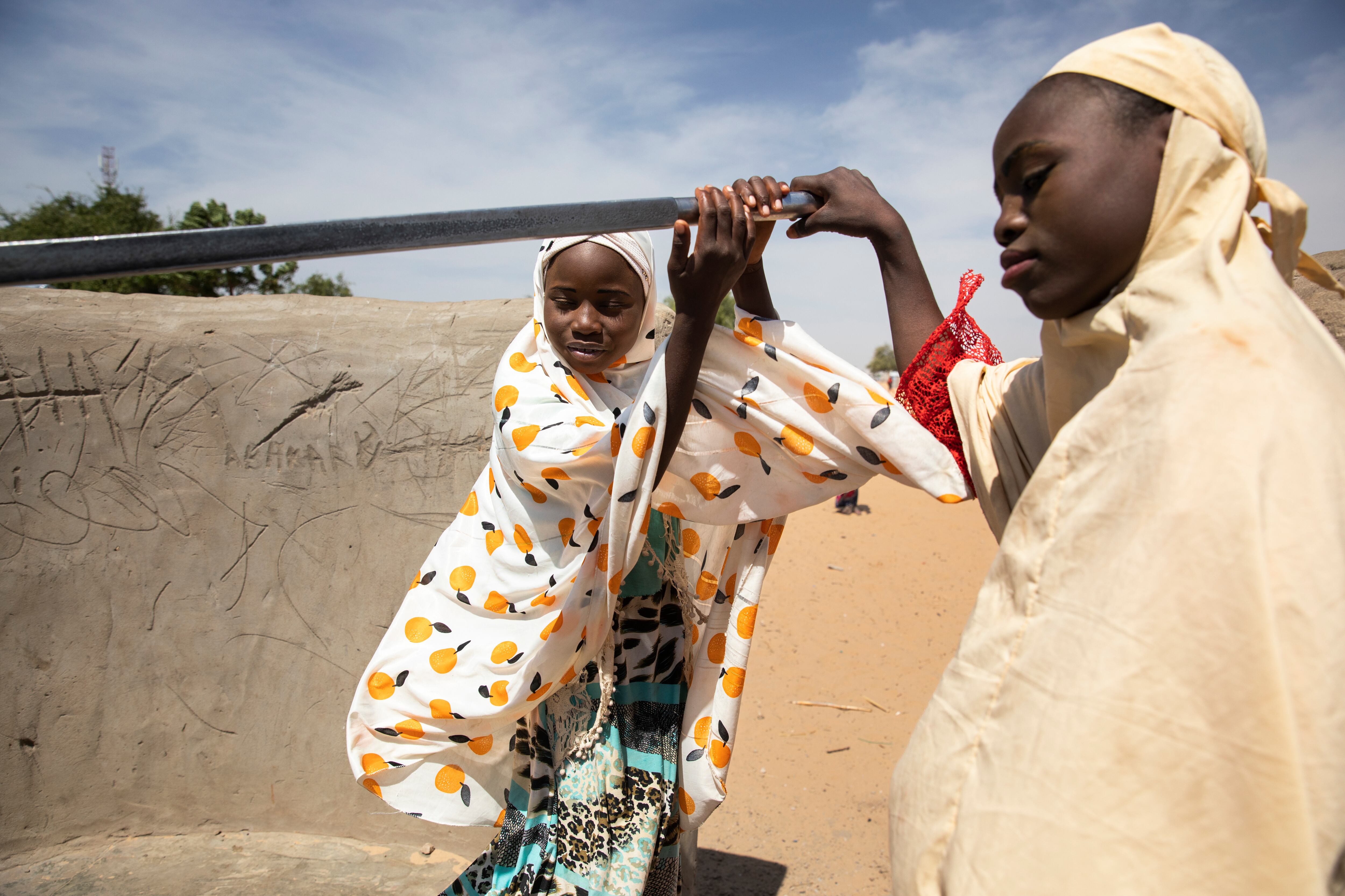 Roukaya y su mejor amiga, Sadya, bombean para obtener agua de un pozo cercano a sus viviendas. A pesar del déficit de nutrientes de Roukaya, esta saca energías a diario para llenar y cargar pesados cubos de agua dos veces al día.