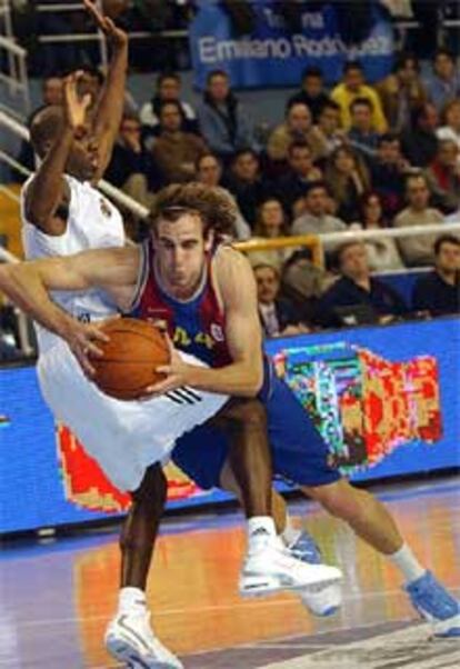 El base madridista Bennett (izqda) trata de frenar la entrada a canasta del escolta Roger Grimau.