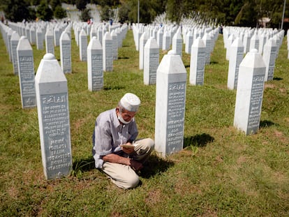 Un hombre reza entre lápidas en Potocari, cerca de Srebrenica (Bosnia), en julio de 2020, durante el 25º aniversario de la matanza de 8.000 musulmanes.