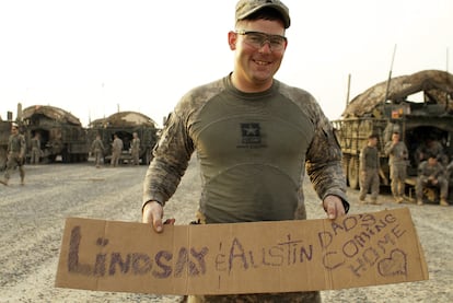 Un sargento muestra un mensaje para su mujer y su hija de dos meses en el que puede leerse "Papá está volviendo a casa".