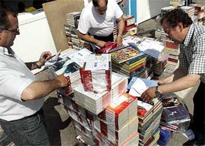 Libreros arreglando sus casetas en el parque del Retiro de Madrid.