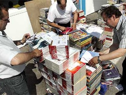 Libreros arreglando sus casetas en el parque del Retiro de Madrid.