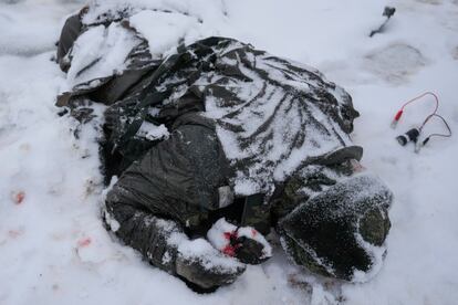 Ofensiva de Rusia en Ucrania: El cuerpo de un militar está cubierto de nieve junto a un vehículo lanzacohetes múltiple militar ruso destruido en las afueras de Kharkiv