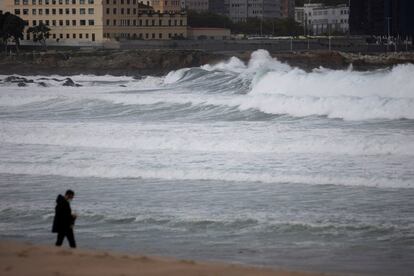 Un hombre pasea por la playa del Orzán en A Coruña, este viernes. Es una de las 29 provincias bajo aviso naranja.