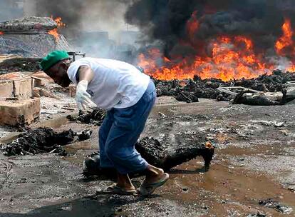 Un miembro del equipo de rescate arrastra los restos de un cuerpo quemado ayer cerca de Lagos, la capital económica de Nigeria.