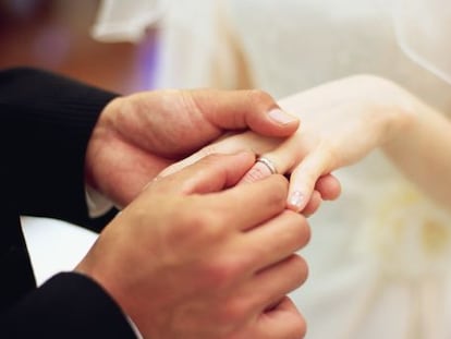 Una pareja intercambia anillos en su boda.