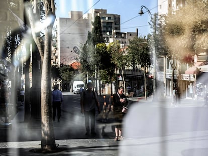 Varias personas se reflejan en el escaparate de una tienda en Jerusalén, este viernes.