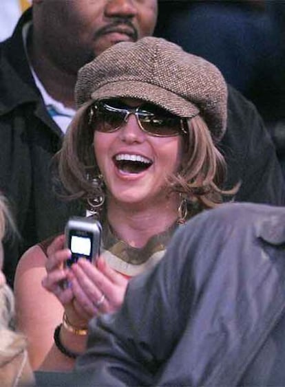 Britney Spears, en un partido de baloncesto, con peluca y gorra.