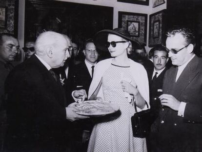 Grace Kelly y Rainiero Grimaldi observan el plato que muestra González Martí, en el Museo Nacional de Cerámica.