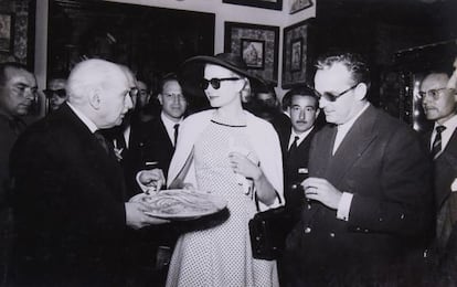 Grace Kelly y Rainiero Grimaldi observan el plato que muestra González Martí, en el Museo Nacional de Cerámica.