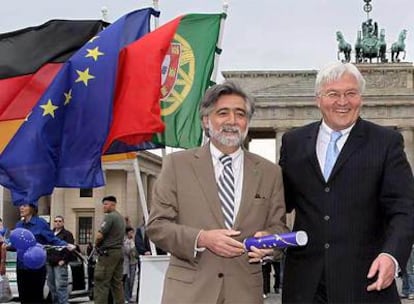 El ministro alemán de Asuntos Exteriores, Frank-Walter Steinmeier (d), entrega un simbólico "testigo" a su homólogo portugués, Luis Amado, frente a la puerta de Brandeburgo