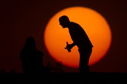 Un hombre toma una cerveza durante el atardecer en Brasilia (Brasil).