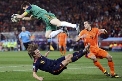 Casillas vuela tras atrapar el balón después de un choque con Puyol.