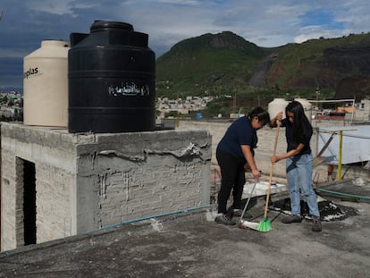 Mujeres limpian el techo de una casa utilizada para recolectar agua de lluvia en la colonia Iztapalpa, Ciudad de México, el 21 de julio.