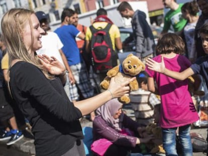 Una trabajadora de la iniciativa 'Ayuda a los Refugiados en Múnich' entrega un oso de peluche.