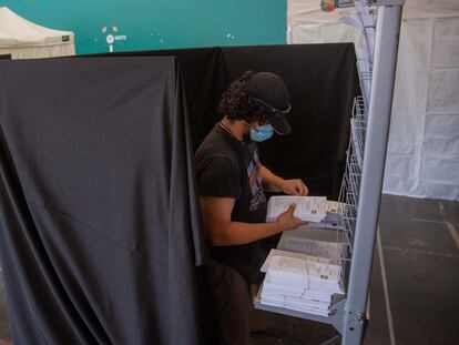 Una persona coloca las papeletas en un colegio electoral vasco, el pasado domingo.