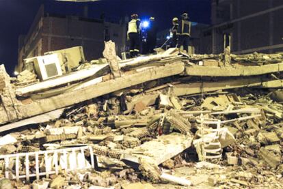 Equipos de rescate buscan entre los escombros de un edicifio destruido por el terremoto en Lorca.