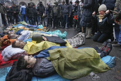 Manifestantes antigubernamentales rodean los cuerpos sin vida de sus compa&ntilde;eros muertos en los enfrentamientos con la polic&iacute;a. 