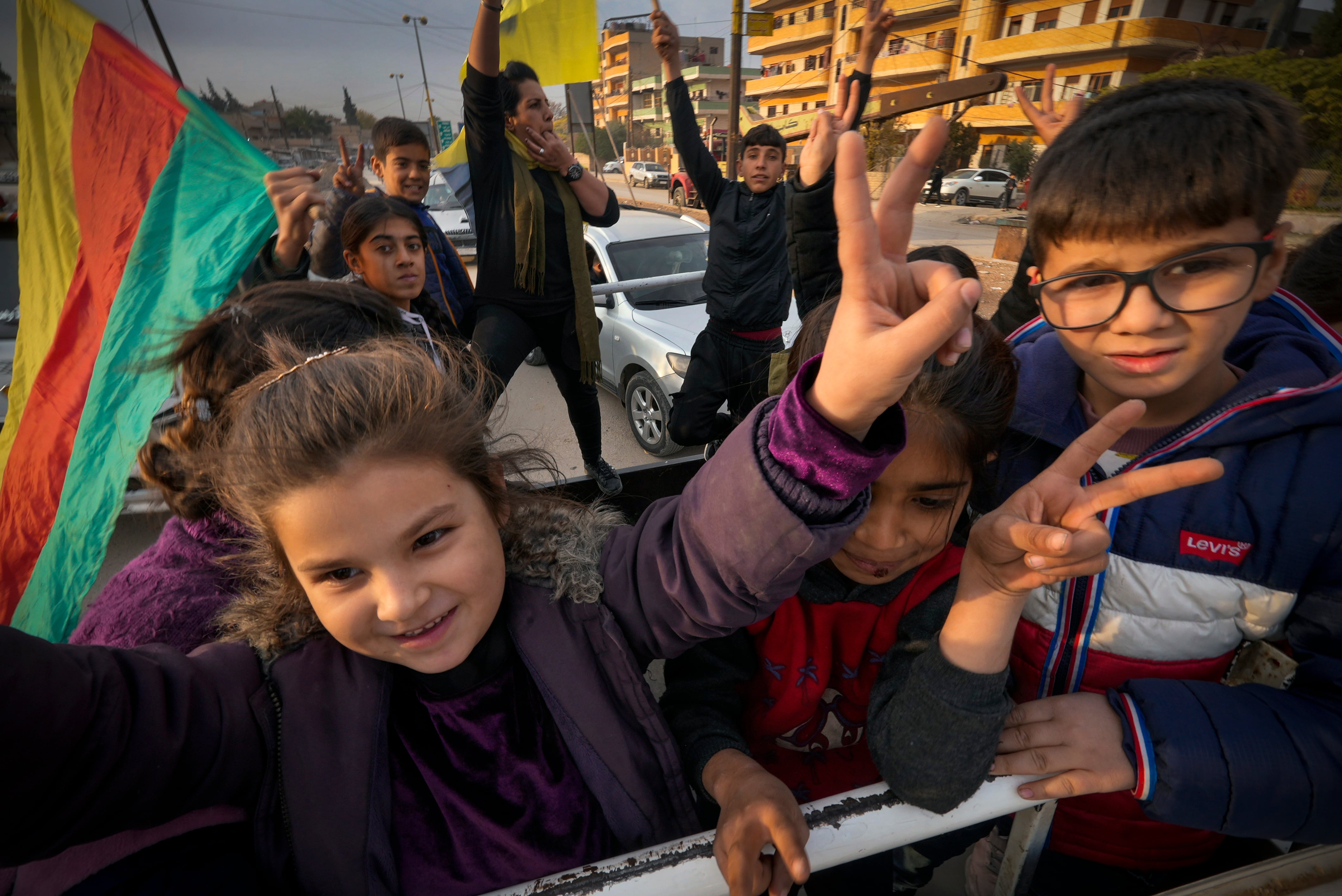 Unos niños hacen el signo de la victoria con los dedos para celebrar la caída de Bachar el Asad, este domingo en Qamishli (Siria).