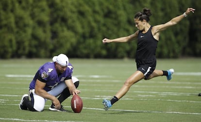 Sam Koch, de los Baltimore Ravens, sujeta el balón para que patee Carli Lloyd desde 55 yardas.