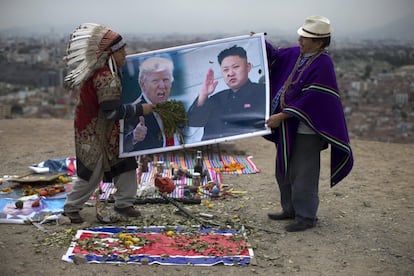 Dos chamanes sostienen un póster de Donald Trump y Kim Jong-un, durante un ritual para la paz entre EE UU y Corea del Norte celebrado en Lima.