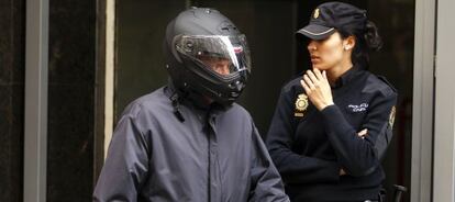 Alfonso García-Pozuelo sale de la Audiencia Nacional con un casco de motorista.