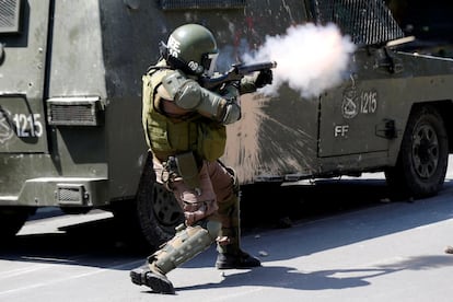 Al menos 716 personas se encuentran detenidas por los disturbios, según informó por la mañana de este domingo el ministro del Interior chileno, Andrés Chadwick. En la imagen, un oficial de la policía antidisturbios dispara un bote de gas lacrimógeno durante una protesta contra el modelo económico estatal de Chile en Santiago, el 20 de octubre de 2019.