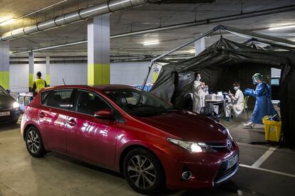 Una persona aguarda en su coche a que los sanitarios del hospital de campaña de Oviedo le realicen las pruebas diagnósticas. Los militares se encargan de filtrar que solo aquellos con cita anticipada puedan someterse a la acción de los sanitarios, siempre protegidos para contener posibles contagios.