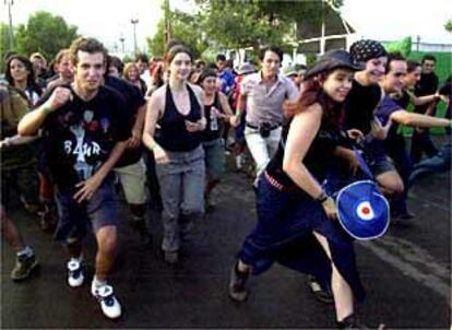 Un grupo de asistentes al Festival de Benicàssim, a la carrera para ocupar la primera fila frente al escenario.