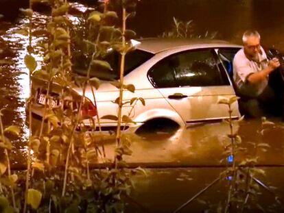 Un hombre, obligado a abandonar su vehículo a causa de un embalsamiento, anoche en Madrid.