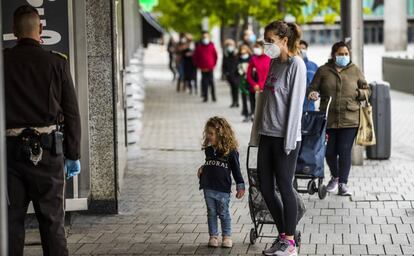 Una mujer y su hija hacen cola para comprar, en la plaza de Felipe II de Madrid.