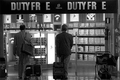 Pasajeros ante una tienda libre de impuestos de la antigua terminal del aeropuerto de Barajas.