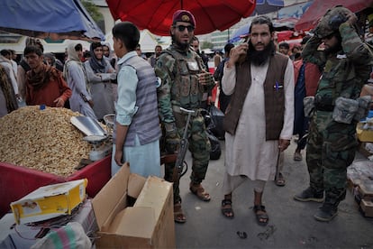 El comandante talibán Mohamed Muslim, de 35 años, pasea protegido por algunos de sus hombres por un mercado de Kabul. 