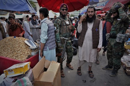 El comandante talibán Mohamed Muslim, de 35 años, pasea protegido por algunos de sus hombres por un mercado de Kabul.