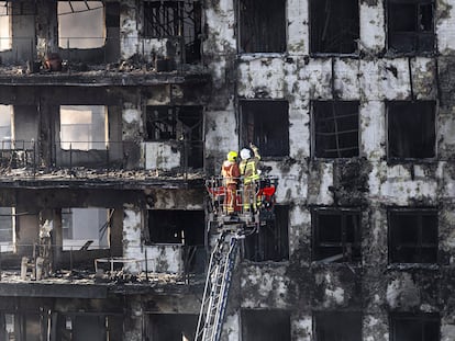 Un grupo de bomberos inspecciona la fachada de las torres incendiadas del barrio del Campanar.