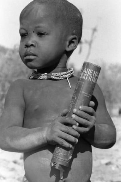 Un niño sostiene una bengala gastada, norte de Namibia, 1987.