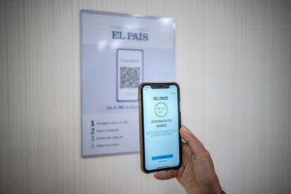 Una mujer en el Hospital HM Puerta del Sur de Móstoles escanea un código QR para leer EL PAÍS.