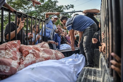 Palestinos transportan los cuerpos de las víctimas para darles sepultura, desde la morgue del hospital Nasser hasta el cementerio, este jueves en la ciudad de Jan Yunis.