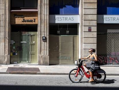 Una mujer pasa ante comercios cerrados en Barcelona durante la pandemia.