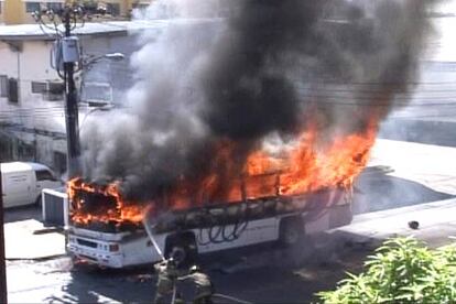 Los bombero intentan acabar con las llamas que envuelven al autobus.