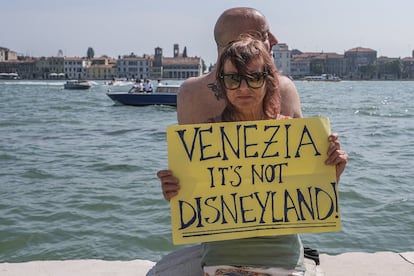 Manifestante aguarda o início do protesto, em 8 de junho de 2019, com o cartaz: "Veneza não é a Disneylândia"