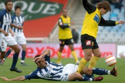 El centrocampista de la Real Sociedad Alvaro Novo intenta arrebatar desde el suelo el balón a Leonardio Daniel Ponzio.